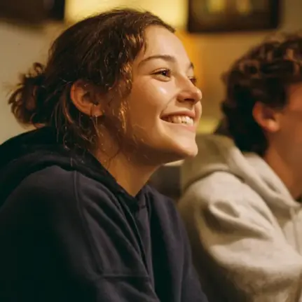 Main living room in a teen rehab facility with adolescents interacting in a safe environment.