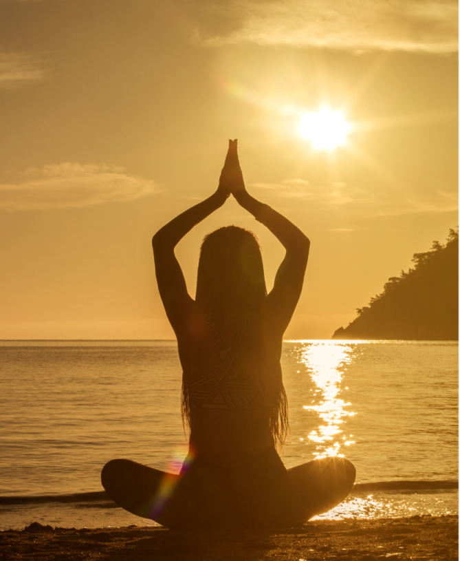 Woman meditating at sunset (peace / mindfulness)