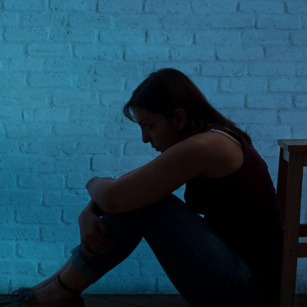 Sad woman sitting alone in darkness