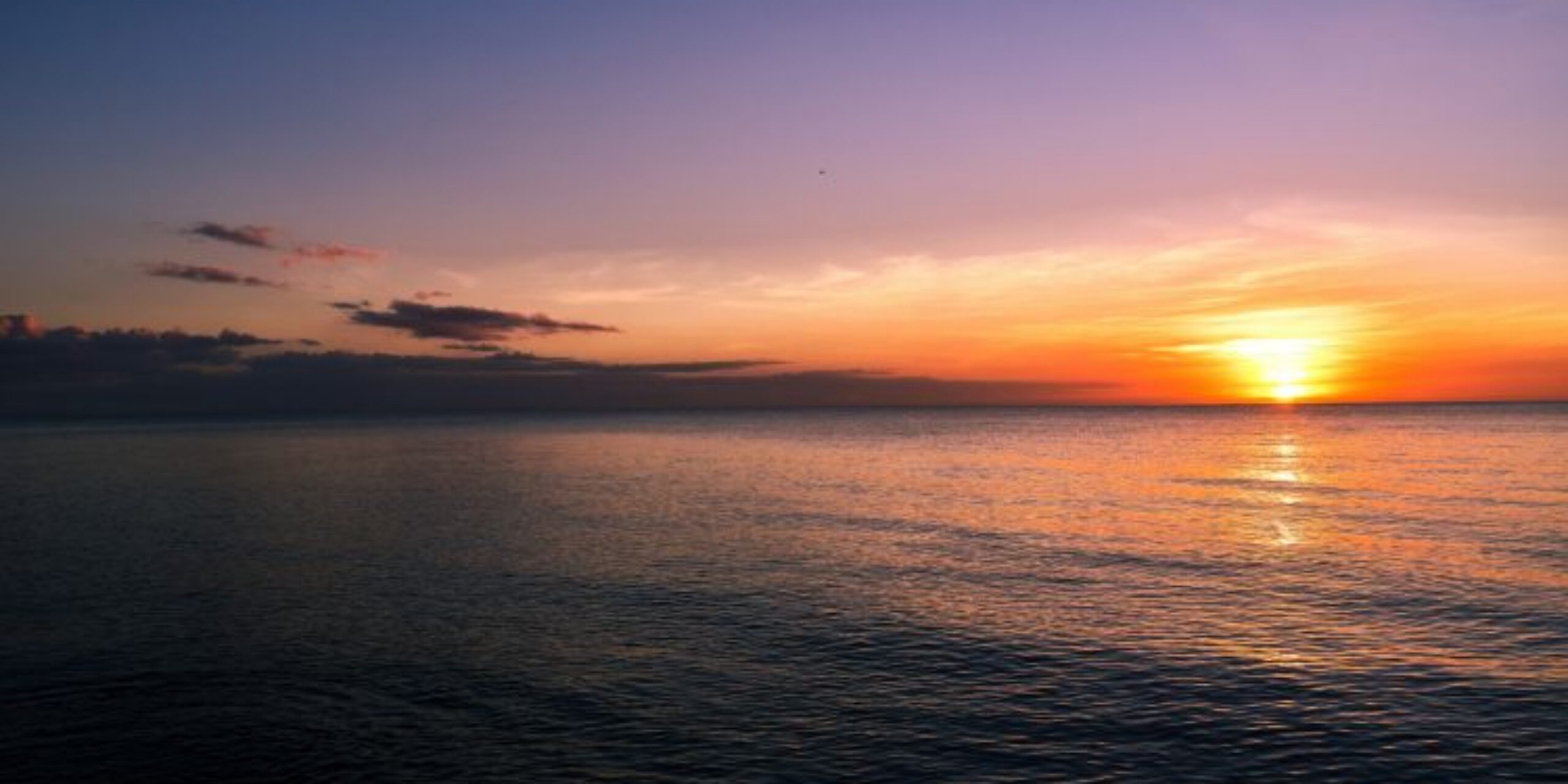 Sunset over calm ocean horizon