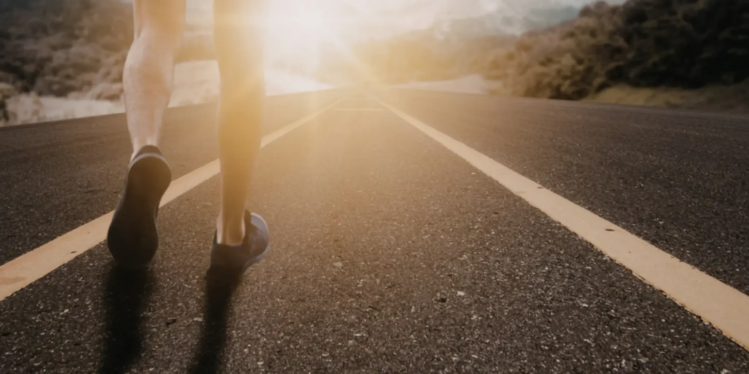 Person walking on road at sunrise