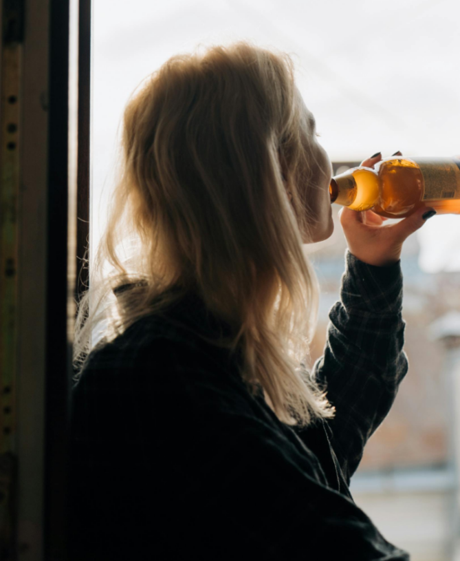 Woman drinking alcohol alone