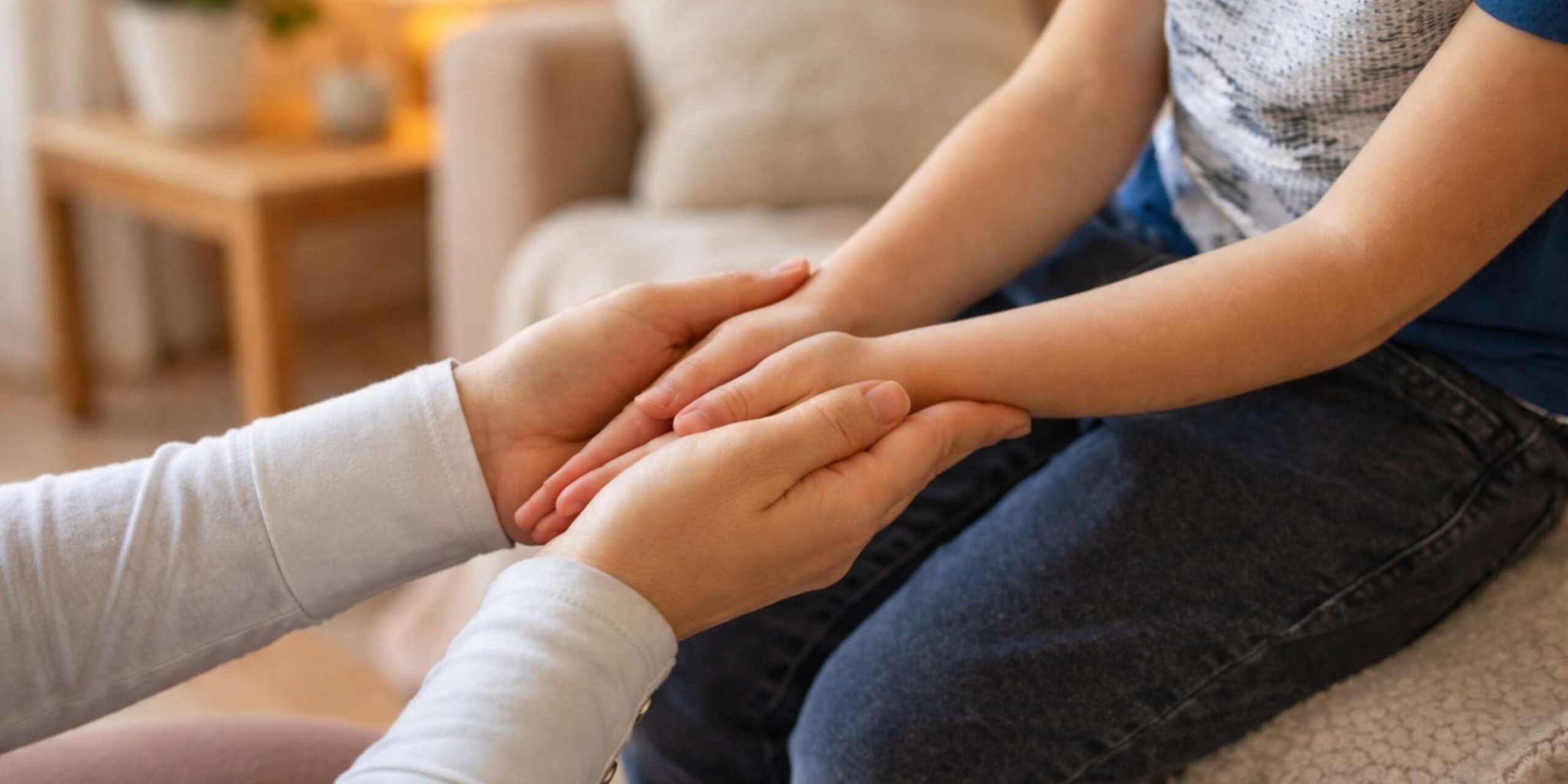Parent holding child hands supportively